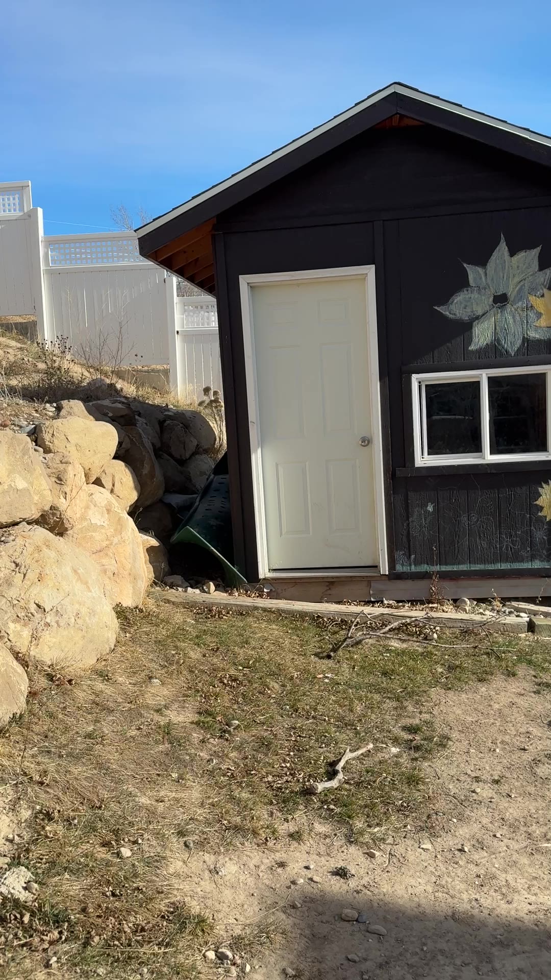 Before: backyard shed beside a boulder slope and bare dirt