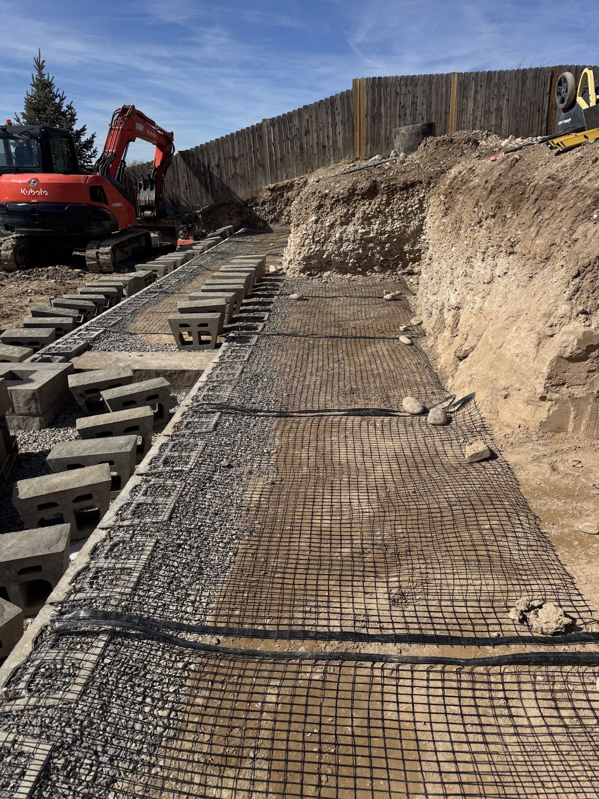 Geogrid reinforcement rolled out behind the block retaining wall