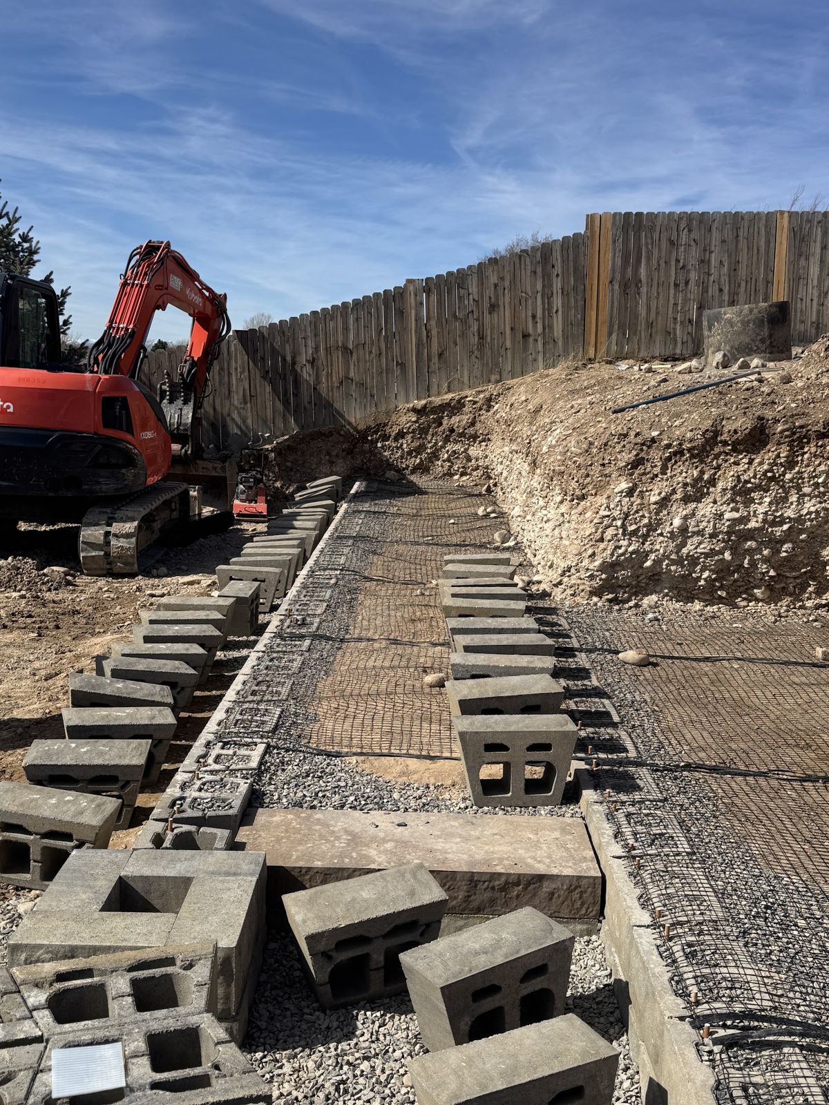 Blocks and geogrid staged for the next course of the retaining wall