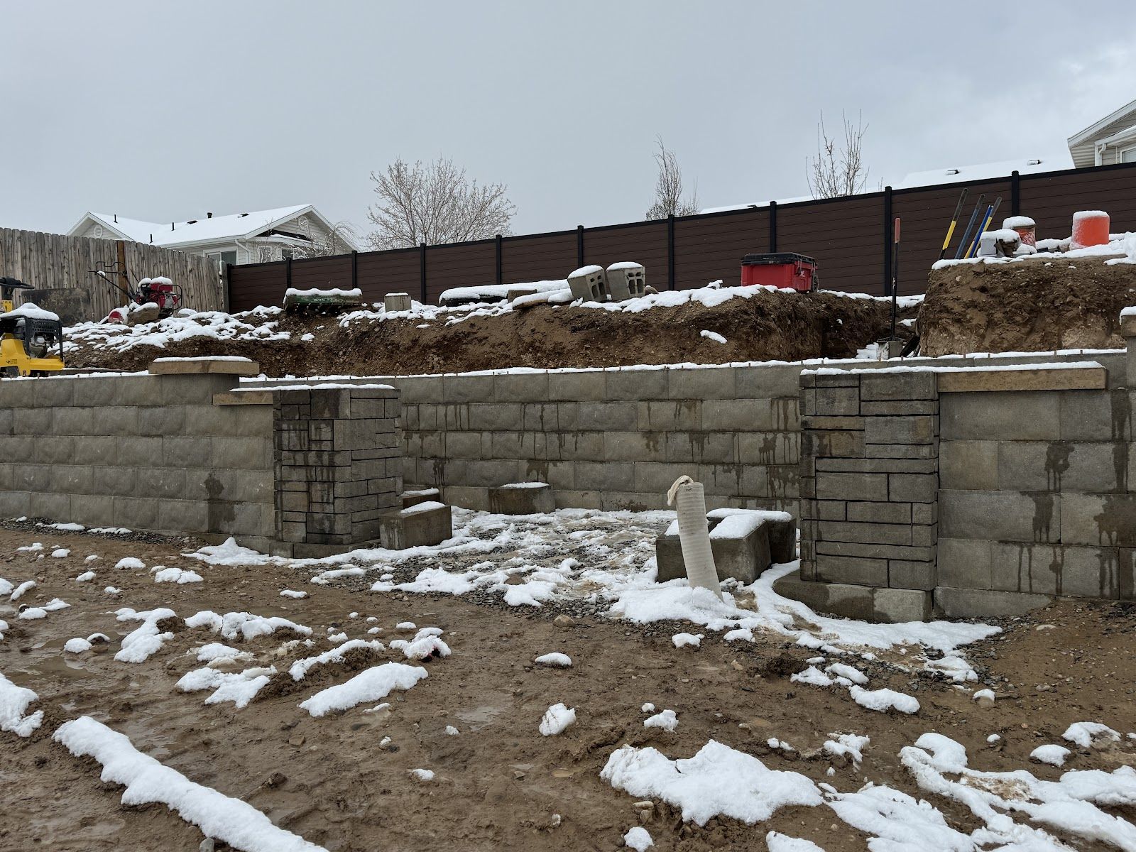 Tall block retaining wall tier with snow on the ground