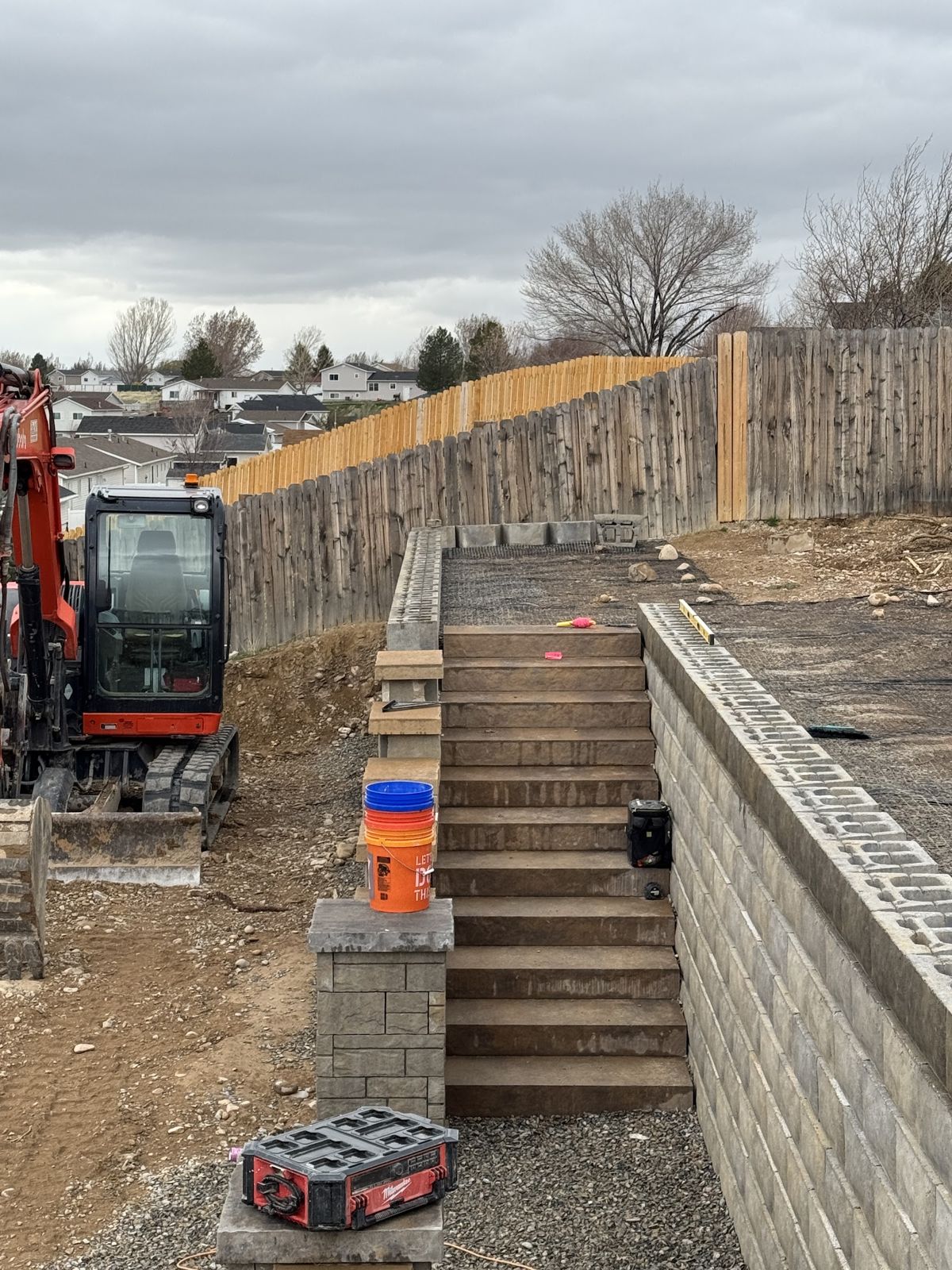 Block steps and wall tier with excavator nearby